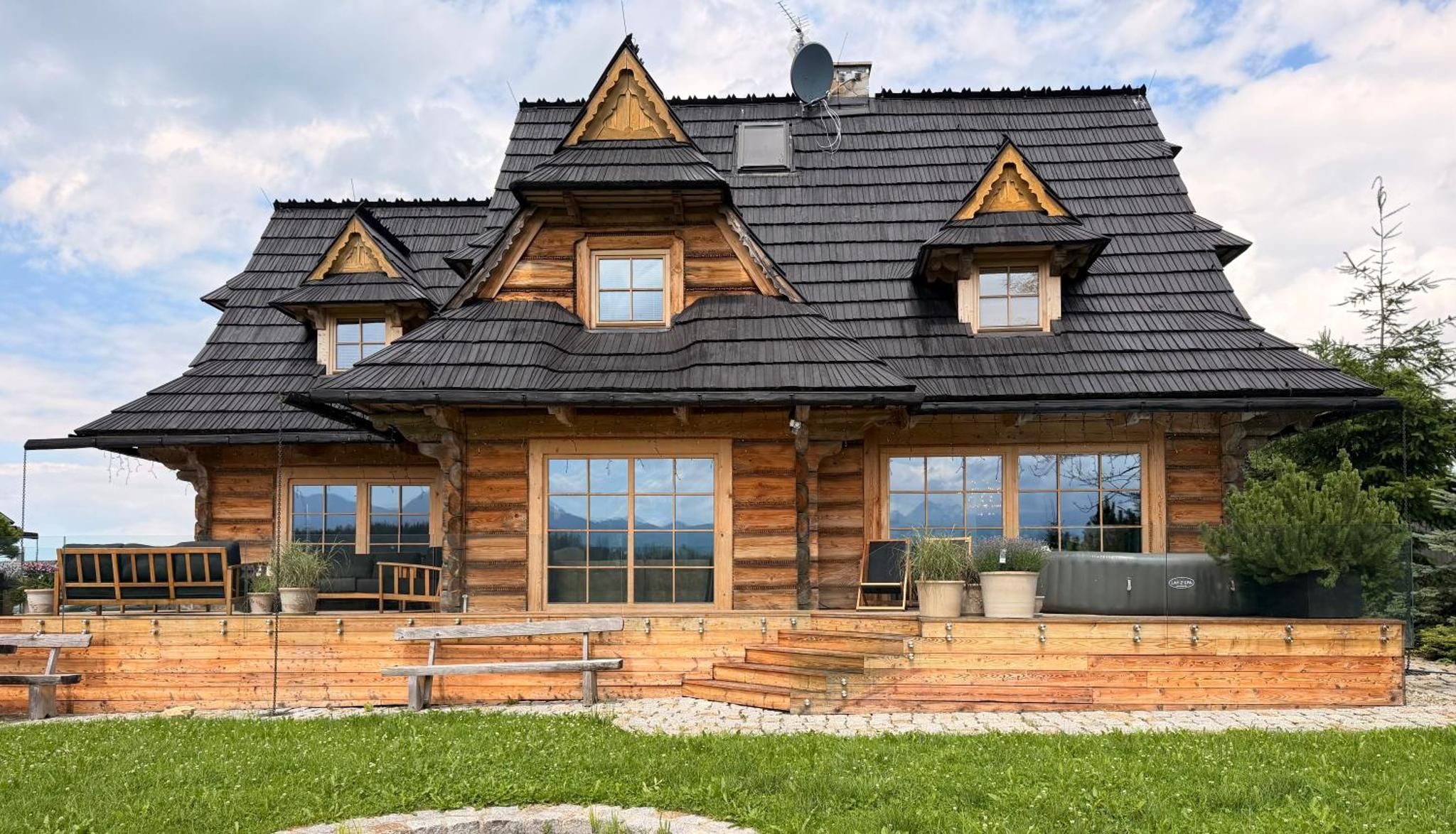 Góralski chalet z bali z ciemnym gontem i tarasem